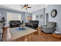 Cozy living room with hardwood floors, large windows, and comfortable seating arrangement at 9204 Malcolm Dr, Covington, GA 30014