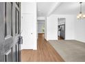 Bright entryway featuring sleek hardwood floors, leading into the open-concept living area and kitchen at 11961 Lovejoy Crossing Way, Hampton, GA 30228