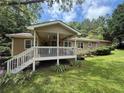 Inviting covered back porch with stairs and ceiling fan overlooking lush green yard at 1537 David Lee St, Acworth, GA 30102
