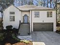 Charming two-story home with stucco exterior, gray garage door and landscaped front yard at 1820 N Creek Cir, Alpharetta, GA 30009