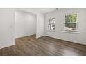 Bright bedroom featuring wood-look floors and a pair of sunlit windows at 1213 Arnhem Dr, Hampton, GA 30228