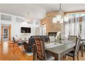 Open-concept living and dining area with a stone fireplace, large windows, and a dining table at 1655 Butler Bridge Rd, Covington, GA 30016