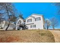 Two-story home with light siding, dark trim, and a large front yard on a sunny day at 7760 Poppy Dr, Winston, GA 30187