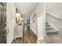Inviting hallway with wood floors, leading to a sunlit living area and a staircase at 1216 Arnhem Dr, Hampton, GA 30228