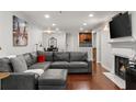Open-concept living room with dark hardwood floors, fireplace, and a large sectional couch and recessed lighting at 3203 Lenox Ne Rd # 1, Atlanta, GA 30324