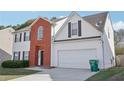 A lovely home with brick and siding, offering a two-car garage, driveway, and trash can at 1618 Blossom Dr, Atlanta, GA 30349