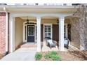 Inviting front porch with decorative columns, pendant lights, and cozy seating area with stylish outdoor chairs at 405 Eaglewood Way, Canton, GA 30115