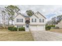 Charming two-story home with white siding, a brick entryway, attached two-car garage, and landscaped front yard at 71 Farm St, Hiram, GA 30141