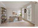 Well-lit home office with a large desk, shelving, and two windows at 727 Vinings Estates Se Dr, Mableton, GA 30126