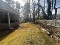 Side yard of a home featuring a mature, grassy lawn with a white picket fence at 2111 Kinridge Trl, Marietta, GA 30062