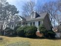 Quaint single-Gathering home with dormer windows, gray siding, and decorative front yard shrubs at 2111 Kinridge Trl, Marietta, GA 30062