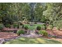 Secluded backyard featuring lush greenery, terraced landscaping, and a stone pathway at 3814 Vermont Ne Rd, Atlanta, GA 30319