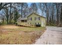 Inviting two-story home with a wooden ramp and driveway, surrounded by mature trees and a spacious yard at 832 Toonigh Rd, Canton, GA 30115