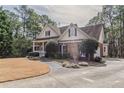 Lovely home featuring a brick facade, lush landscaping, paved walkway, and a circular driveway at 1621 Annapolis Way, Grayson, GA 30017