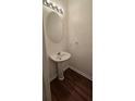 Bathroom featuring a pedestal sink, modern lighting, and sleek flooring at 911 Redwood Dr, Norcross, GA 30093