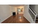 Spacious living room with wood floors, a cozy fireplace, and staircase leading to the upper level at 911 Redwood Dr, Norcross, GA 30093