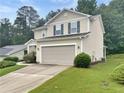 Side view of a well-maintained home with a two-car garage, landscaping, and lush green lawn at 265 Edinburgh Ln, Woodstock, GA 30188