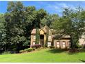 Beautiful two-story brick home surrounded by lush greenery and mature trees at 403 Glenhurst Trce, Canton, GA 30115