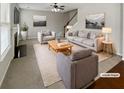 Bright living room features a fireplace, staircase, and neutral decor at 12981 Dartmore Cir, Alpharetta, GA 30005