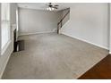 An empty living room features neutral walls, a fireplace, and stairs at 12981 Dartmore Cir, Alpharetta, GA 30005
