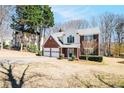Charming two-story home with a brick front and attached two-car garage surrounded by mature trees at 2225 Saint Thomas Way, Suwanee, GA 30024