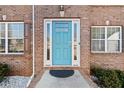 Stylish blue front door with glass panels and white trim, flanked by windows and green bushes at 4046 Arnolds Mill Opas, Douglasville, GA 30135