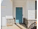 The front door is a classic teal with beautiful stone pillars at 828 Royal Red Ct, Mcdonough, GA 30253