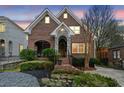 Charming brick home with stone archway, manicured landscaping and inviting front entrance at dusk at 1181 Lanier Ne Blvd, Atlanta, GA 30306
