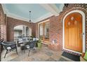 Inviting covered porch with brick columns, seating area, and arched doorway to home at 1181 Lanier Ne Blvd, Atlanta, GA 30306