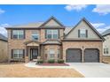 Charming two-story brick home with a well-manicured lawn and attached two-car garage at 1695 Stone Meadow Rd, Lithonia, GA 30058