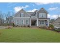 Charming two-story home with a well-manicured lawn and a welcoming front porch on a sunny day at 430 Parkbrook Way, Canton, GA 30114