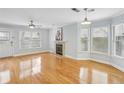 Bright living room with fireplace, ceiling fan, and multiple windows, showcasing hardwood floors at 1002 Defoors Nw Lndg, Atlanta, GA 30318