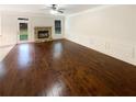 Bright living room featuring hardwood floors, a cozy stone fireplace, and white wainscoting at 6503 Foggy Oak Dr, Fairburn, GA 30213