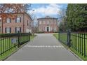 Home entrance with gated access and a circular driveway leading to an elegant brick residence at 4084 Peachtree Dunwoody Ne Rd, Atlanta, GA 30342