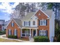 Two-story brick home featuring classic shutters, white trim, and a well-maintained lawn and inviting front porch at 6641 Poplar Grove Way, Stone Mountain, GA 30087