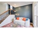 Cozy sitting area features a plush couch, unique wallpaper, and a staircase with wood and iron details at 6641 Poplar Grove Way, Stone Mountain, GA 30087