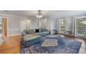 Comfortable living room with hardwood floors, large windows offering natural light, and a stylish blue sofa at 135 Cowan Trl, Stockbridge, GA 30281