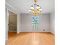 An elegant dining room features hardwood floors, ample natural light, and a classic chandelier at 1864 Gloucester Ct, Snellville, GA 30078