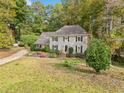 Traditional home with a well-kept lawn surrounded by lush trees, providing a serene and private setting at 1864 Gloucester Ct, Snellville, GA 30078