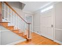 Inviting foyer with hardwood floors, a staircase with wooden handrail, and a view to the front door at 1864 Gloucester Ct, Snellville, GA 30078