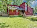 Charming exterior of home with red wood paneling, large windows, and a well-maintained front yard at 2375 Justine Ter, Lithia Springs, GA 30122