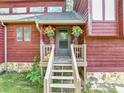 Covered front porch with decorative plants, wood railing and steps that leads up to the front door at 2375 Justine Ter, Lithia Springs, GA 30122