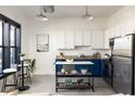 Stylish kitchen featuring white cabinets, blue lower cabinets, stainless steel appliances, and a marble island at 791 Wylie Se St # 105, Atlanta, GA 30316