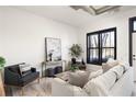 Bright living room with neutral furniture, decor, white brick wall, and a large window with black trim at 791 Wylie Se St # 105, Atlanta, GA 30316