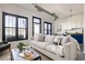 Bright living room with modern white brick walls, black framed windows, and a view into the kitchen at 791 Wylie Se St # 105, Atlanta, GA 30316