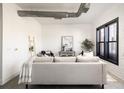 Bright living room with neutral furniture, decor, a ladder, and a large window with black trim at 791 Wylie Se St # 105, Atlanta, GA 30316