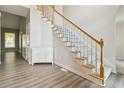 Bright foyer showcases hardwood floors, a staircase with white wooden handrail, and a storage cabinet at 3605 Summit Gate Dr, Suwanee, GA 30024