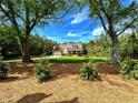 A picturesque home set back amongst towering trees with a manicured front lawn at 136 Rainey Rd, Temple, GA 30179