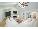 Bright living room with vaulted ceilings, stone fireplace, modern ceiling fan, and cozy white sectional sofa at 140 Pine Glade Trce, Roswell, GA 30075