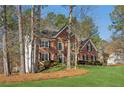 Beautiful brick home with manicured lawn and traditional architectural details at 7115 Doncaster Ct, Cumming, GA 30040